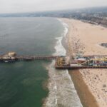 Aerial photograph of Santa Monica Pier and beach, showcasing the coastline and amusement park.