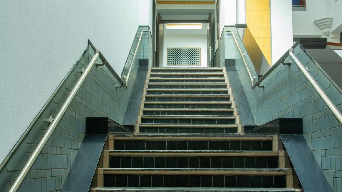 A sleek indoor staircase featuring metal railings and tiled steps in a contemporary setting.