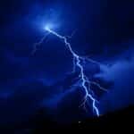 A powerful lightning bolt illuminating a dark nighttime sky in Georgetown, Texas.
