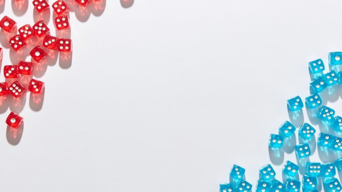 A flat lay of red and blue transparent dice on a white background, perfect for game night themes.