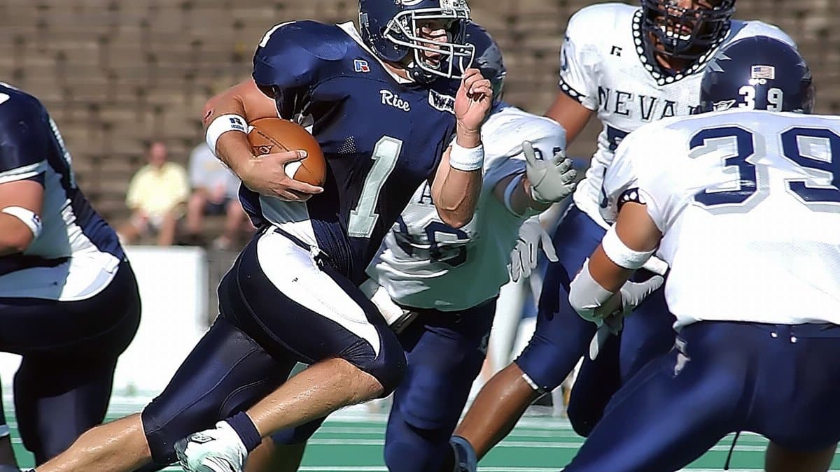 Athletes compete fiercely in an intense American football match, showcasing skill and teamwork on the field.