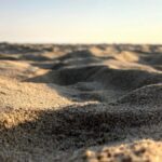 Detailed view of sand dunes at Huntington Beach showing texture and sunlight.