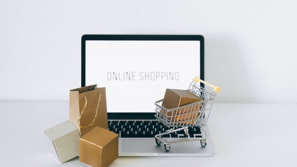 Laptop displaying online shopping with boxes and cart, representing ecommerce.