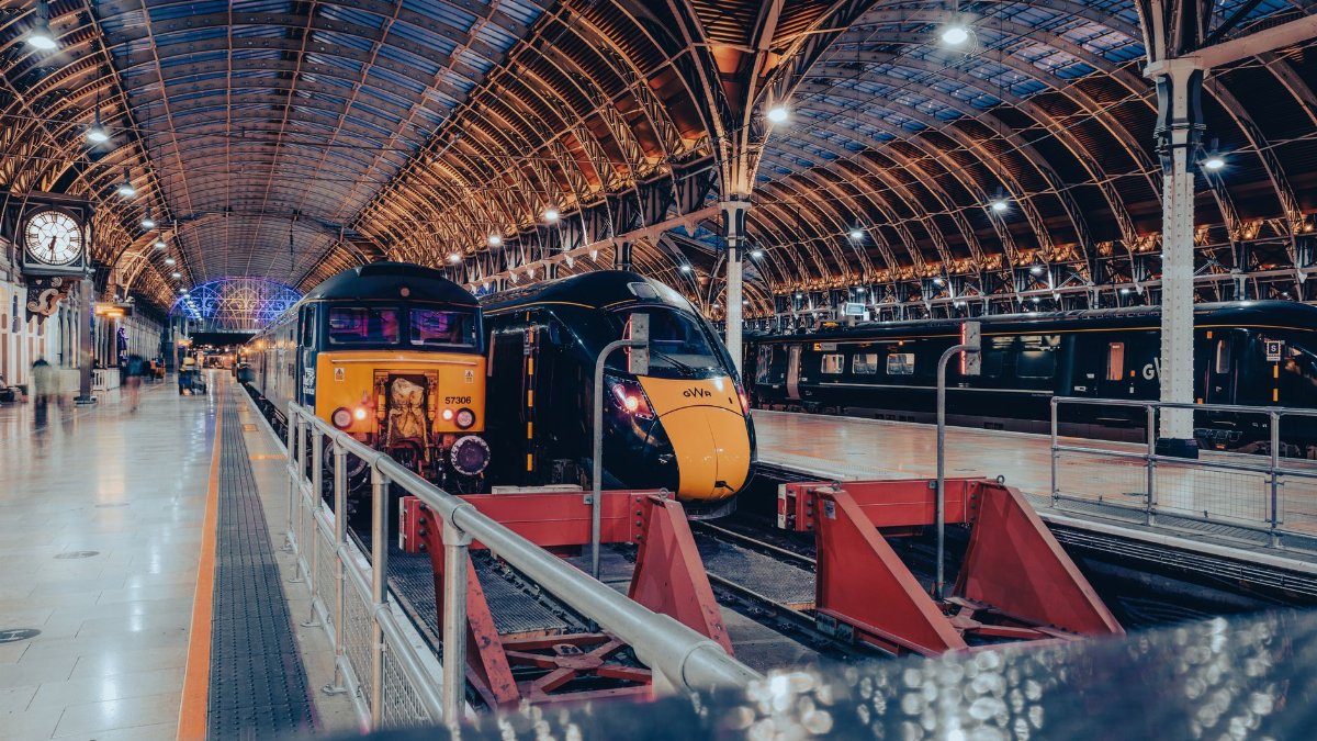 London's Paddington Station showcasing modern trains under its iconic roof archway.