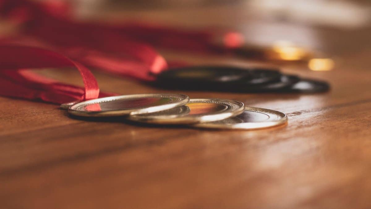 Close-up view of medals on a wooden table, showcasing bronze, silver, and gold awards.