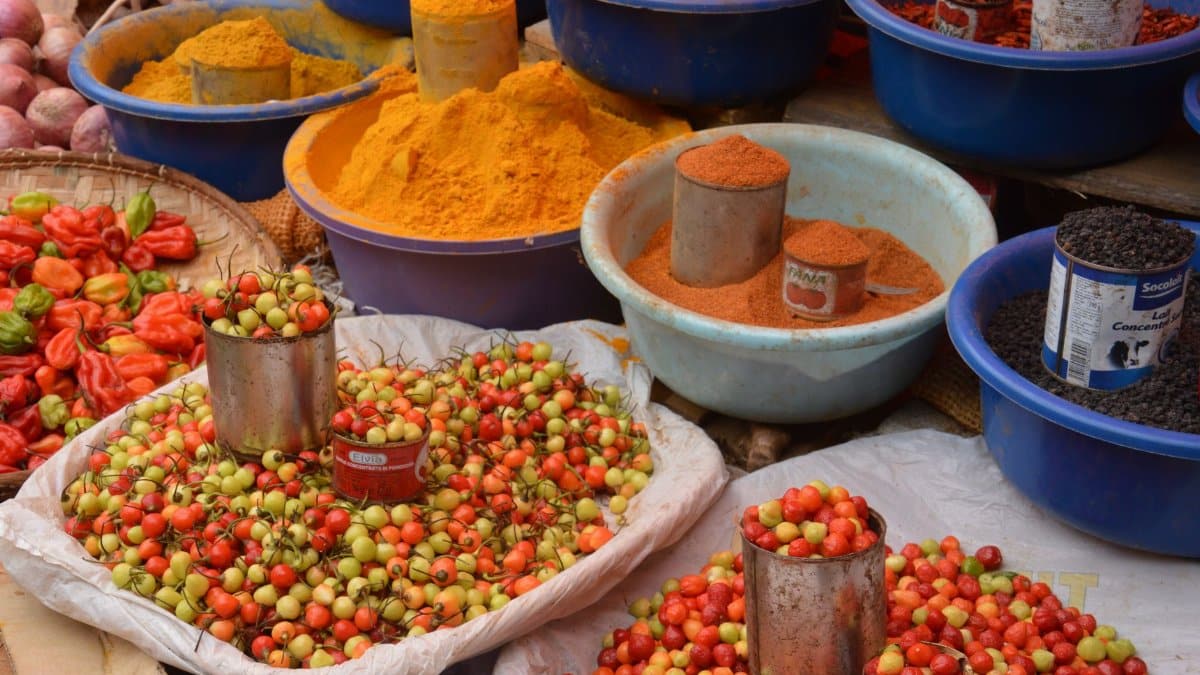 Colorful spices and fresh produce beautifully arranged at an outdoor market.