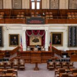 The Texas House of Representatives chamber, featuring legislative seats and historical portraits.