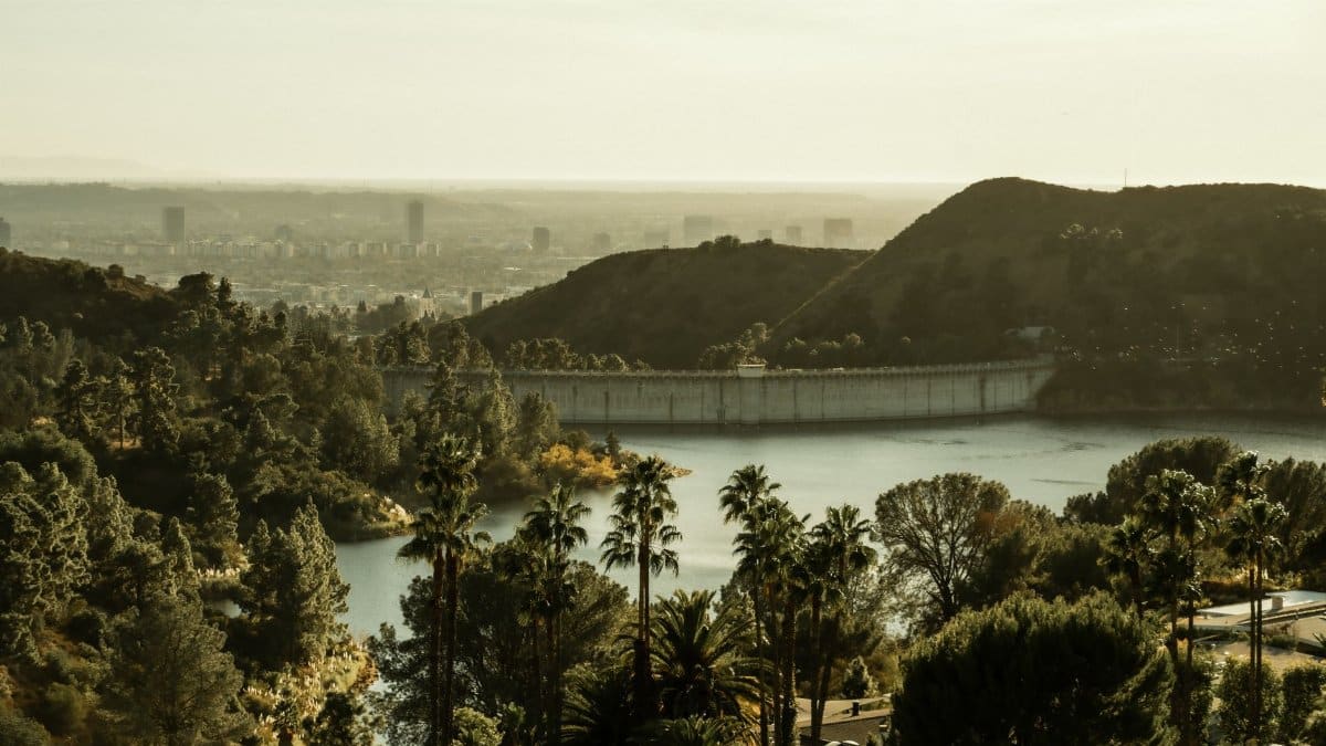 Amazing scenery of Hollywood Reservoir and dam amidst green verdant trees and hills in California on sunny day
