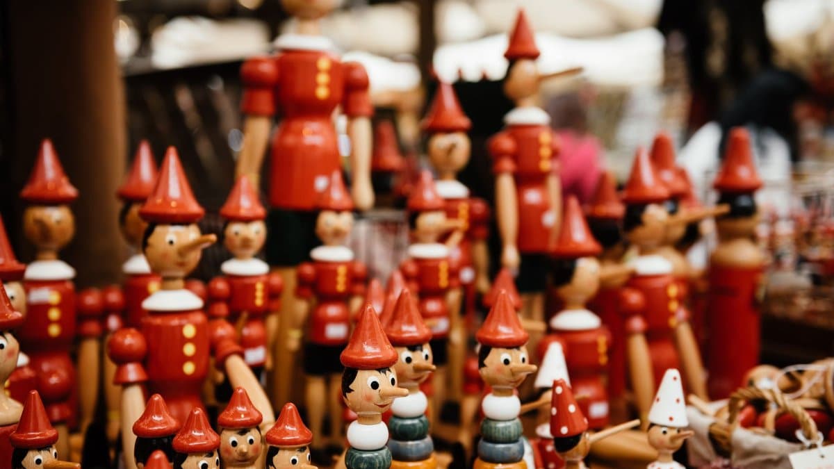 Close-up of handmade wooden Pinocchio toys at a market. Perfect for traditional and souvenir themes.