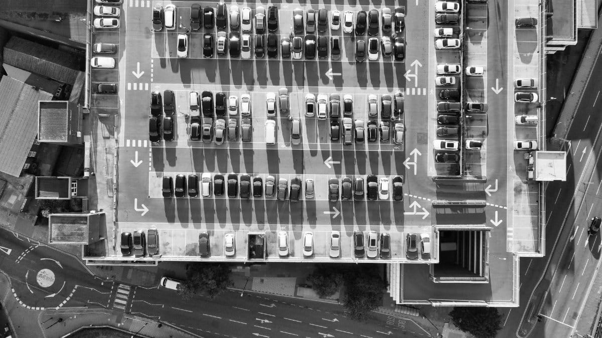 Black and white aerial view of a parking garage in Luton, England, showcasing parked cars and urban layout.