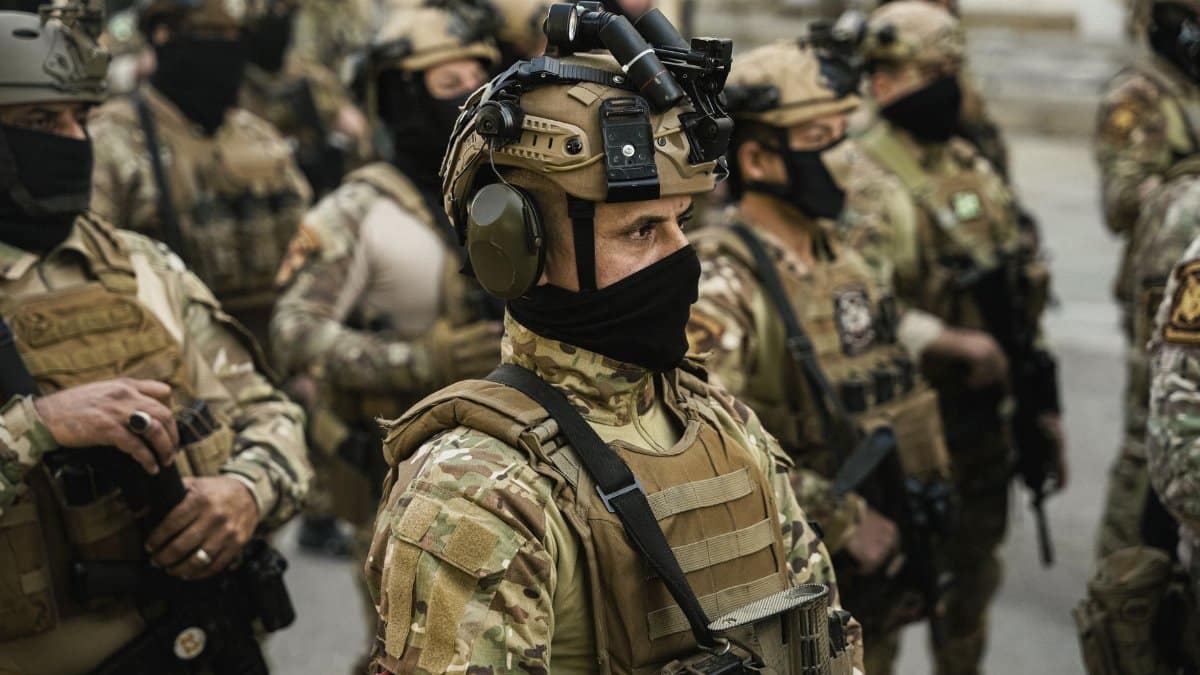 Group of soldiers in tactical gear standing in formation during a military operation.