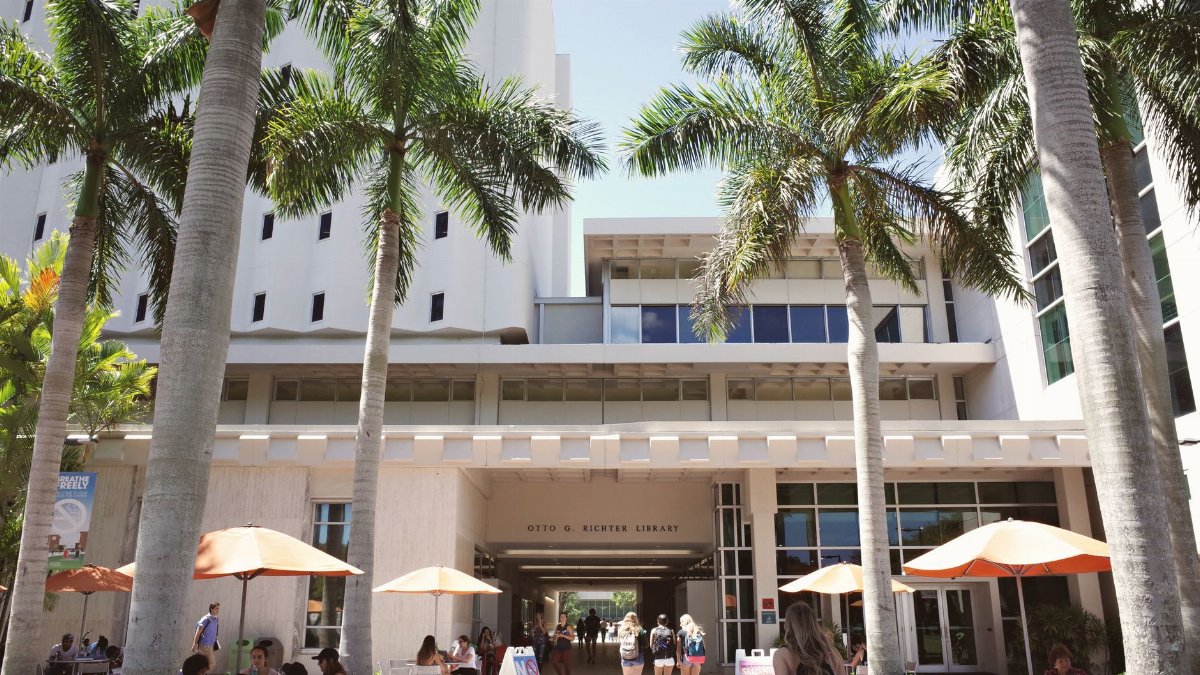 Vibrant University of Miami campus scene with students near Otto G. Richter Library.
