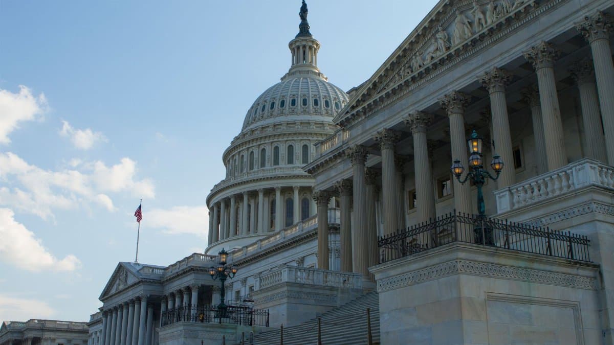 Classic view of the historic US Capitol Building in Washington, DC, with a clear blue sky.