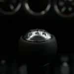 Detailed view of a manual shift knob in a vehicle, highlighting the gears.