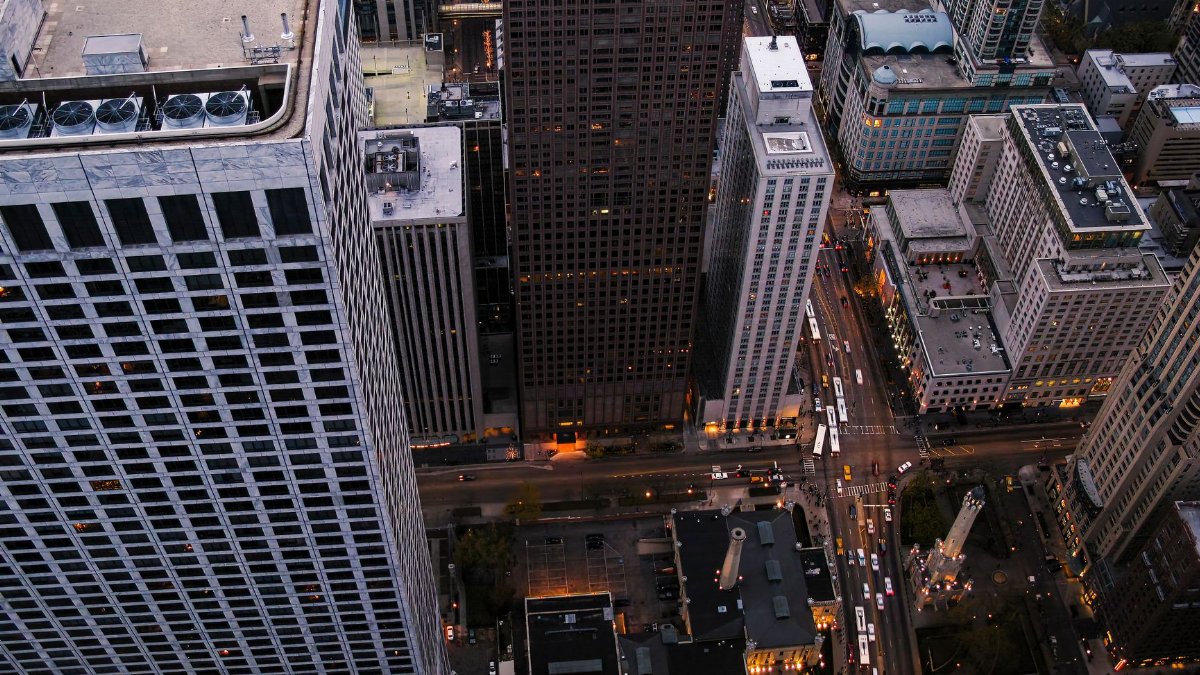 High angle view of a modern city skyline featuring tall skyscrapers and bustling streets at dusk.
