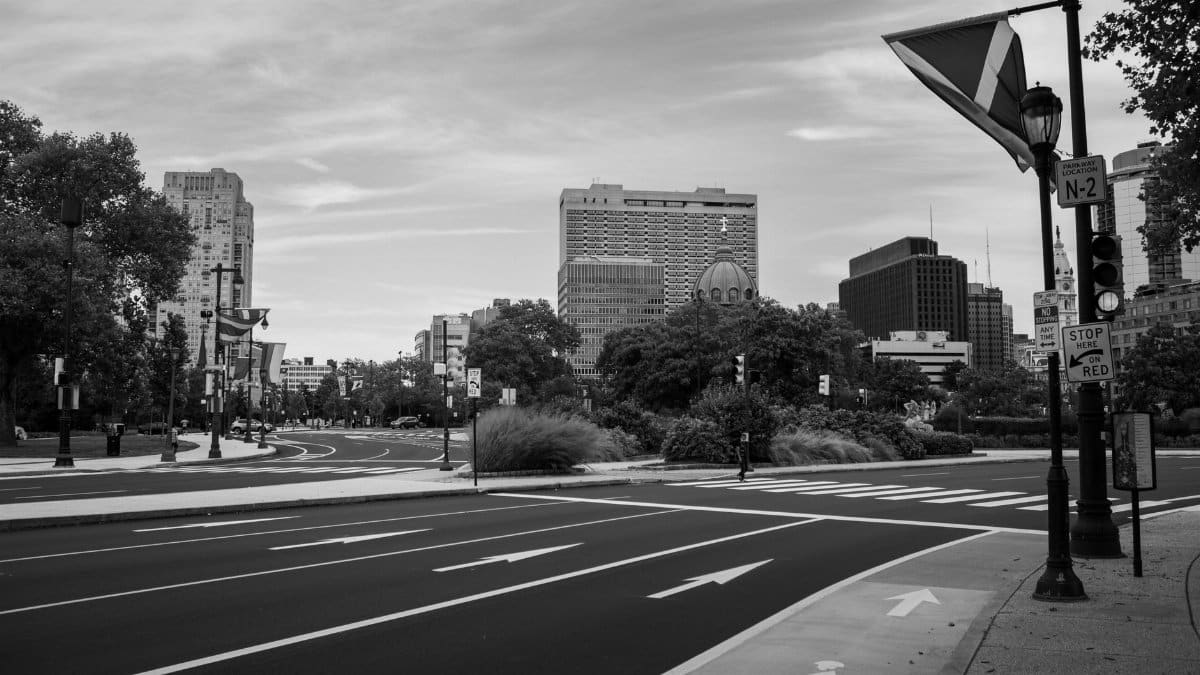 A grayscale view of Philadelphia's urban street scene featuring modern buildings and clear road markings.