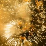 Colorful fireworks bursting in celebration during a vibrant night festival.