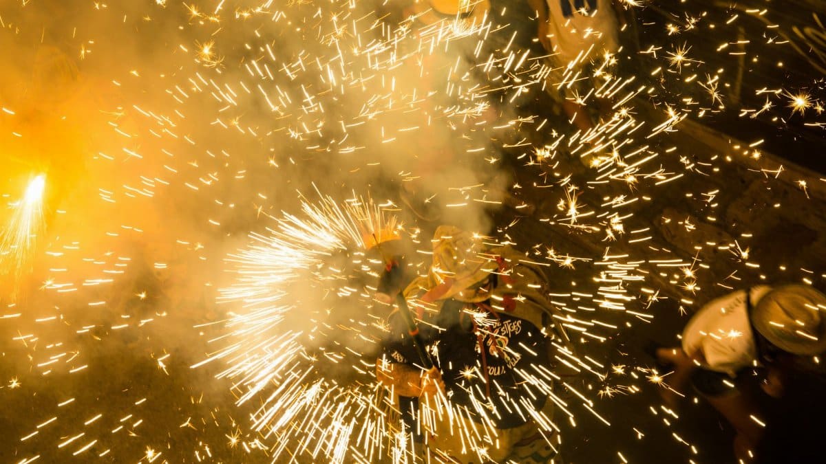 Colorful fireworks bursting in celebration during a vibrant night festival.