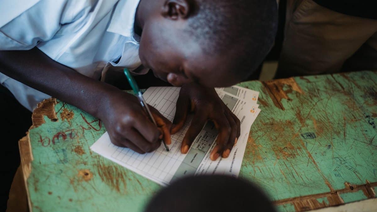 Focused student writing in a classroom setting, capturing educational engagement.