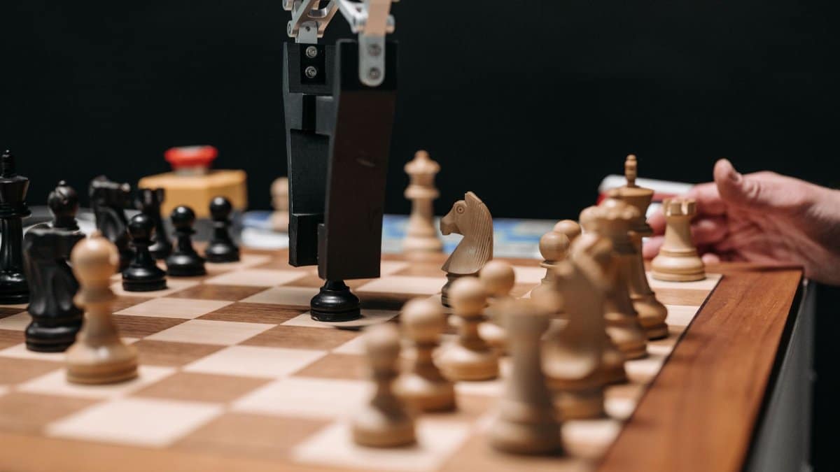 Close-up of a robotic arm playing chess against a human, showcasing AI technology in a classic board game setting.