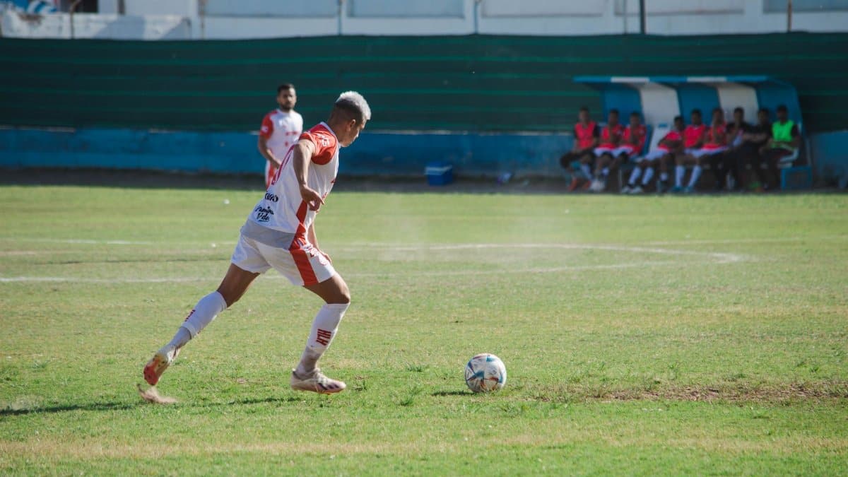 Male soccer player in action on the field during a sunny day match.