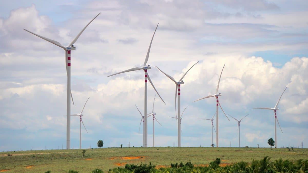 A scenic landscape featuring multiple wind turbines against a cloudy sky, symbolizing renewable energy.