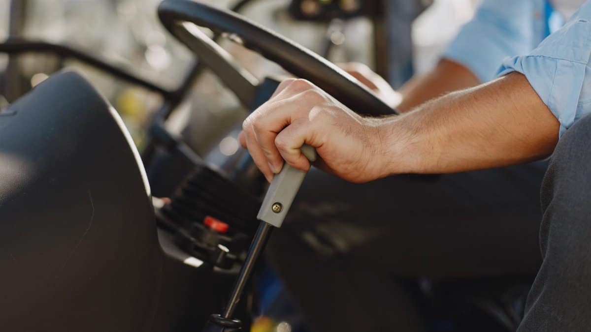 Detailed view of a man driving using the gear stick of a vehicle.