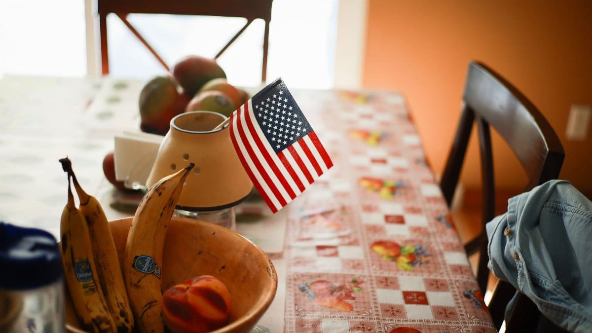 A cozy indoor scene with a small American flag on a fruit-themed table.