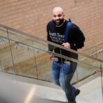 A student confidently ascends steps inside South Texas College of Law building.
