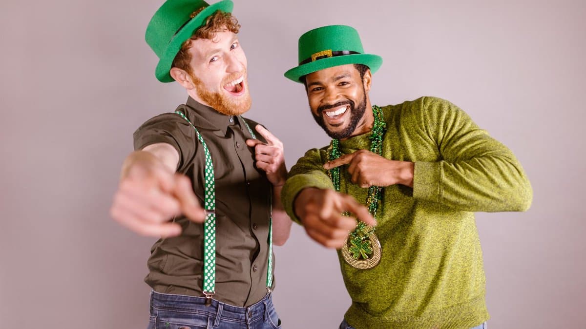 Two friends celebrating St. Patrick's Day with green hats and accessories, enjoying a fun moment.