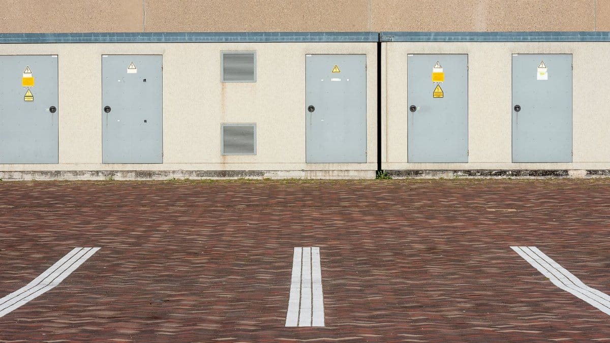 View of an industrial building exterior with parking lines and utility doors.