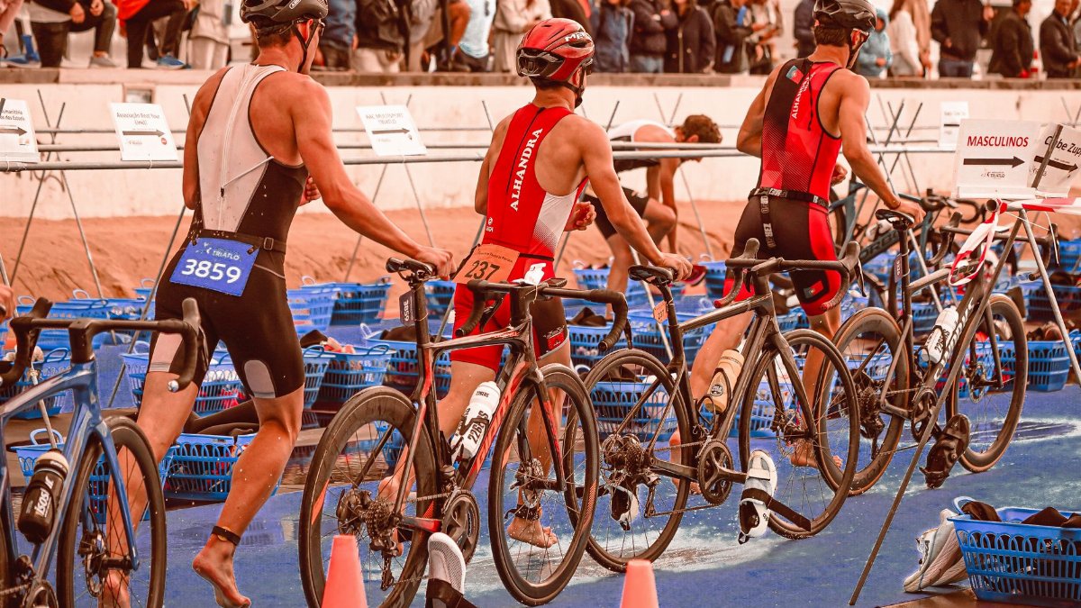 Athletes transition from swimming to cycling at a triathlon event.