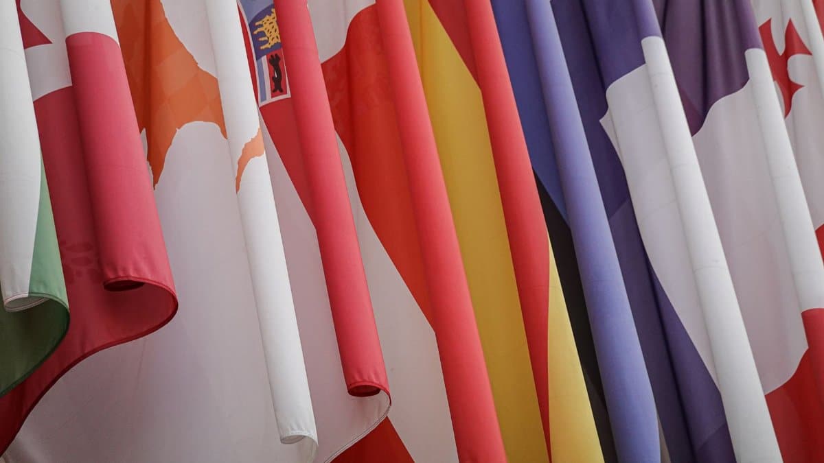 Vibrant display of various international flags closely hanging together.