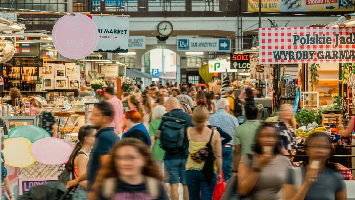 Explore the vibrant Wrocław indoor market with people shopping and local stalls.