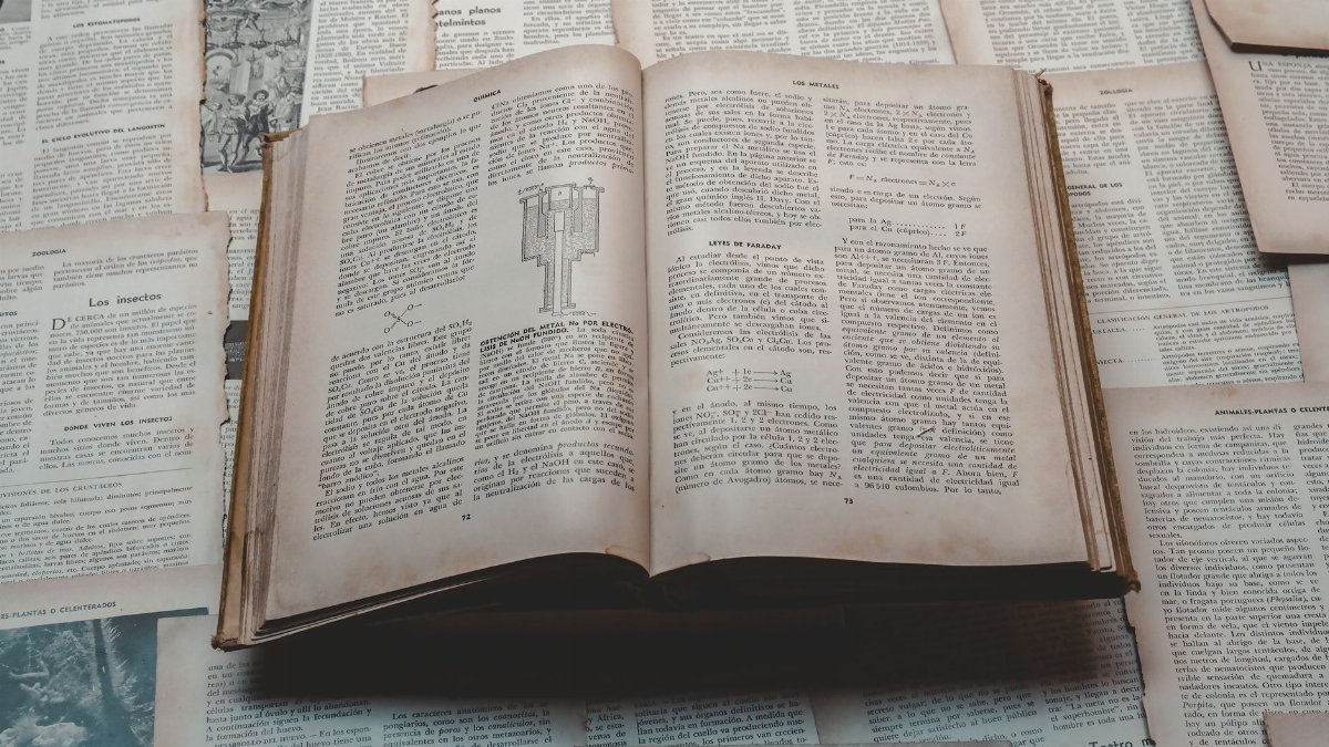 Explore a classic open book surrounded by vintage papers, perfect for historical and educational themes.
