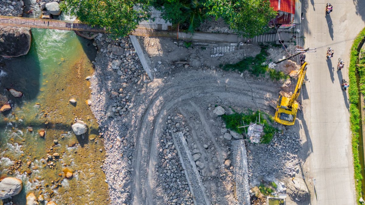 Aerial view of a construction site with excavators and river, Cebu City, Philippines.