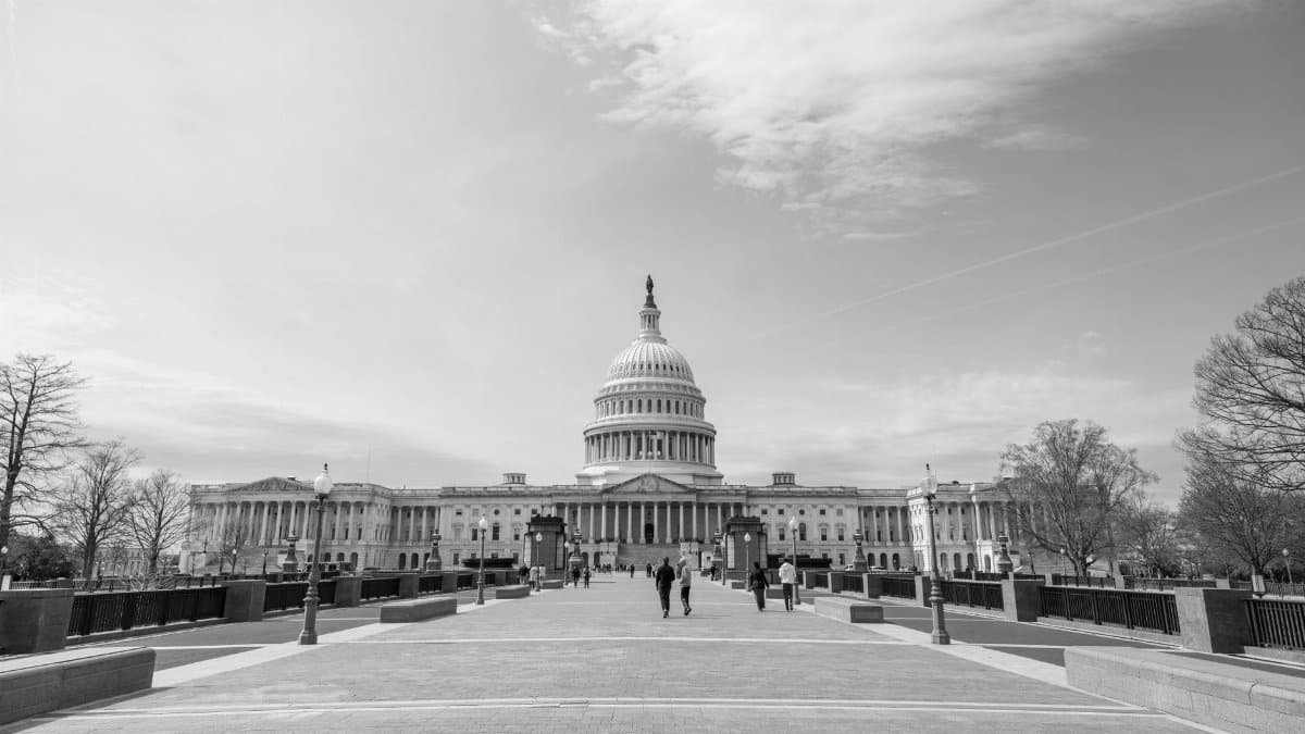 A black and white photo of the US Capitol in Washington, D.C. showcasing its architectural grandeur.