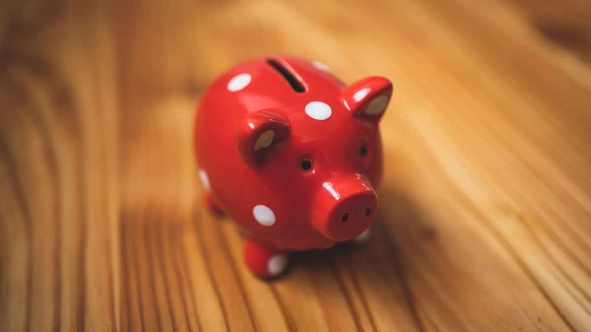 Close-up of a red polka dot piggy bank on a wooden surface, symbolizing savings.