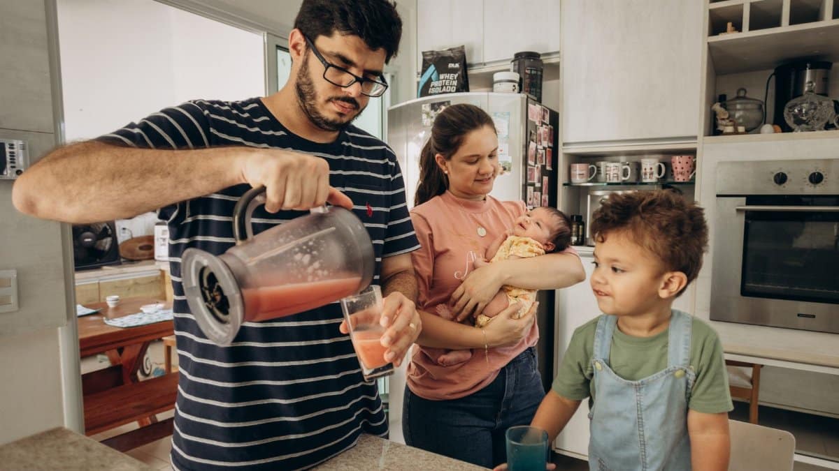 A family enjoys a morning together in their kitchen, making fresh juice.