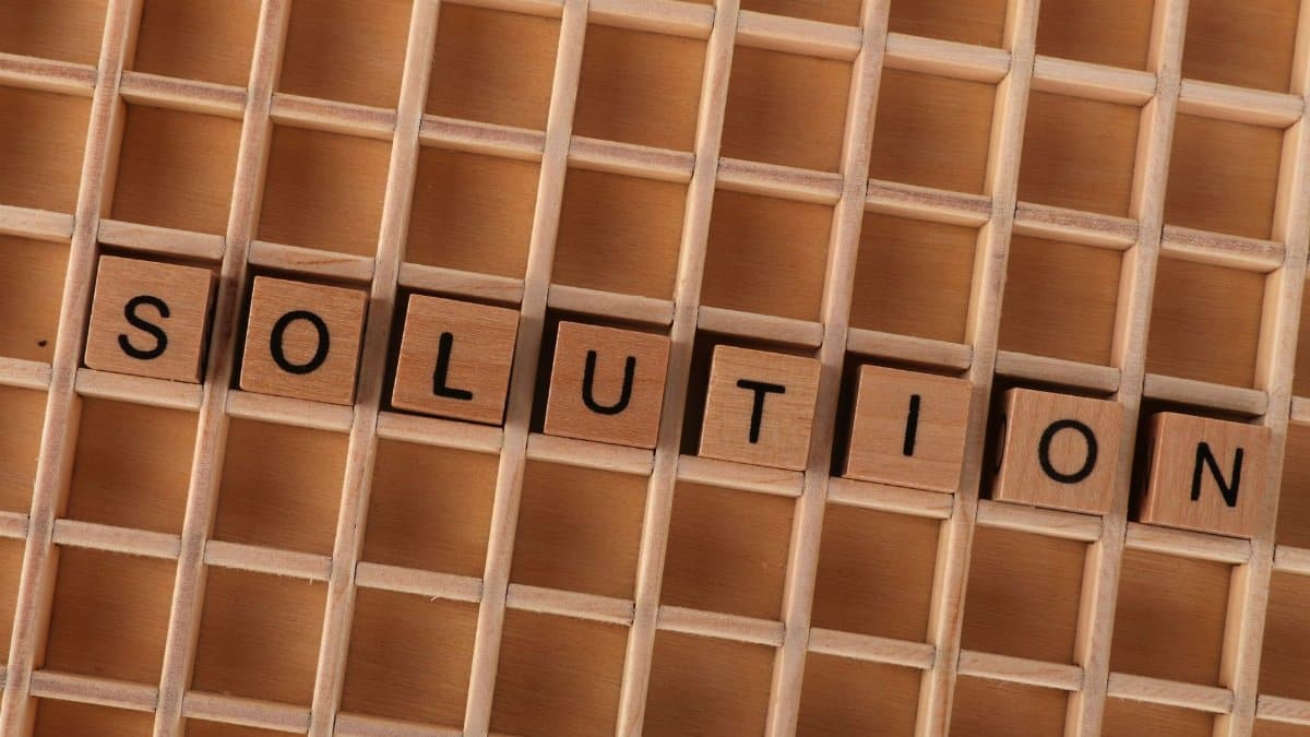 Wooden blocks spelling 'solution' in a grid, symbolizing problem-solving.