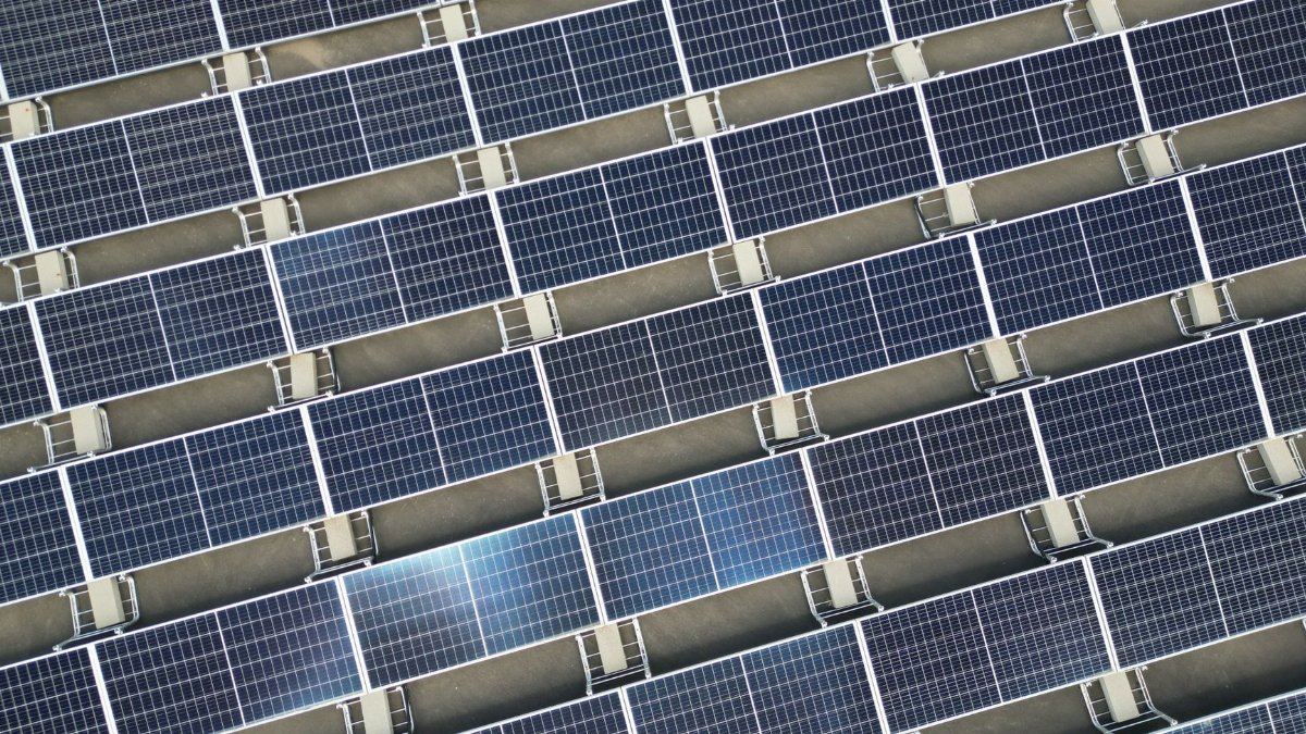 Array of solar panels in grid layout viewed from above promoting renewable energy