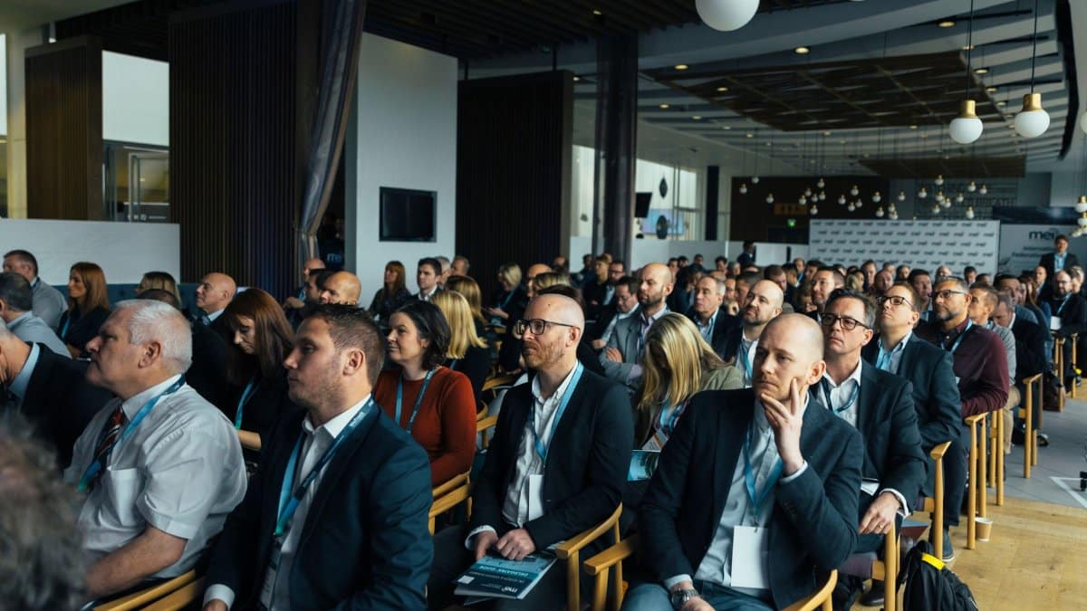 Business professionals attentively listening at an indoor conference meeting.