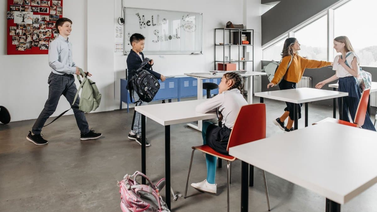 Kids chatting and settling into a modern classroom environment, showcasing school life.