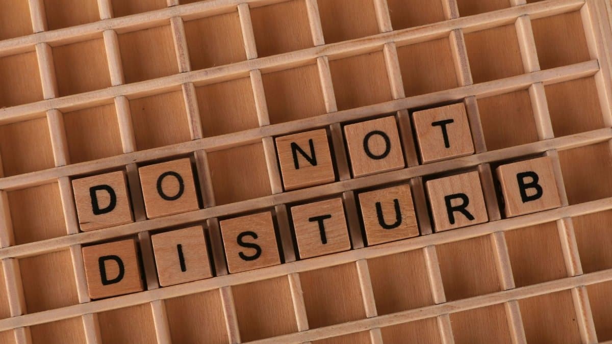 Wooden Scrabble tiles arranged on a grid spelling out 'Do Not Disturb' for privacy concept.