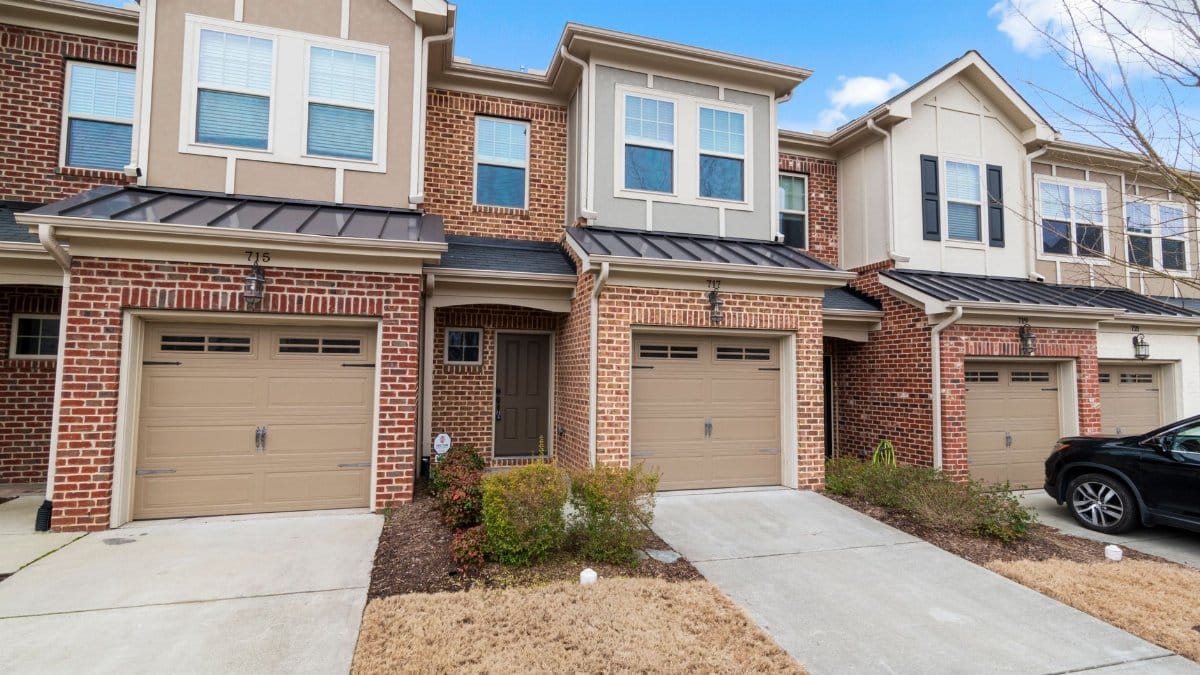 Charming row of modern townhouses featuring brick facades and attached garages.