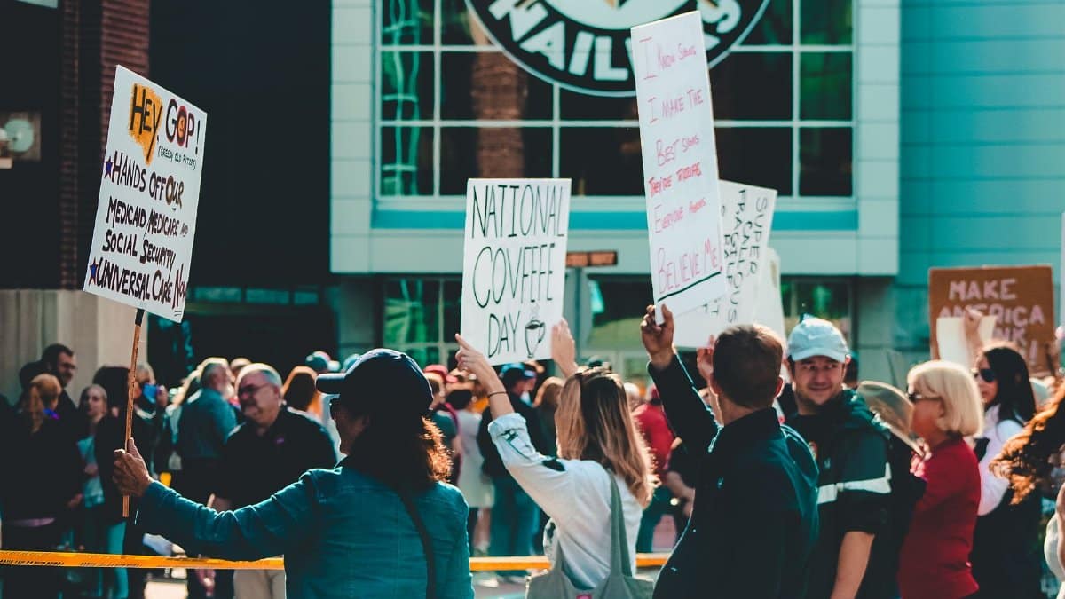 Vibrant scene of people demonstrating outdoors with signs advocating political messages.