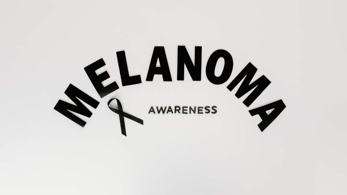 Melanoma awareness concept featuring text and ribbon on white background.