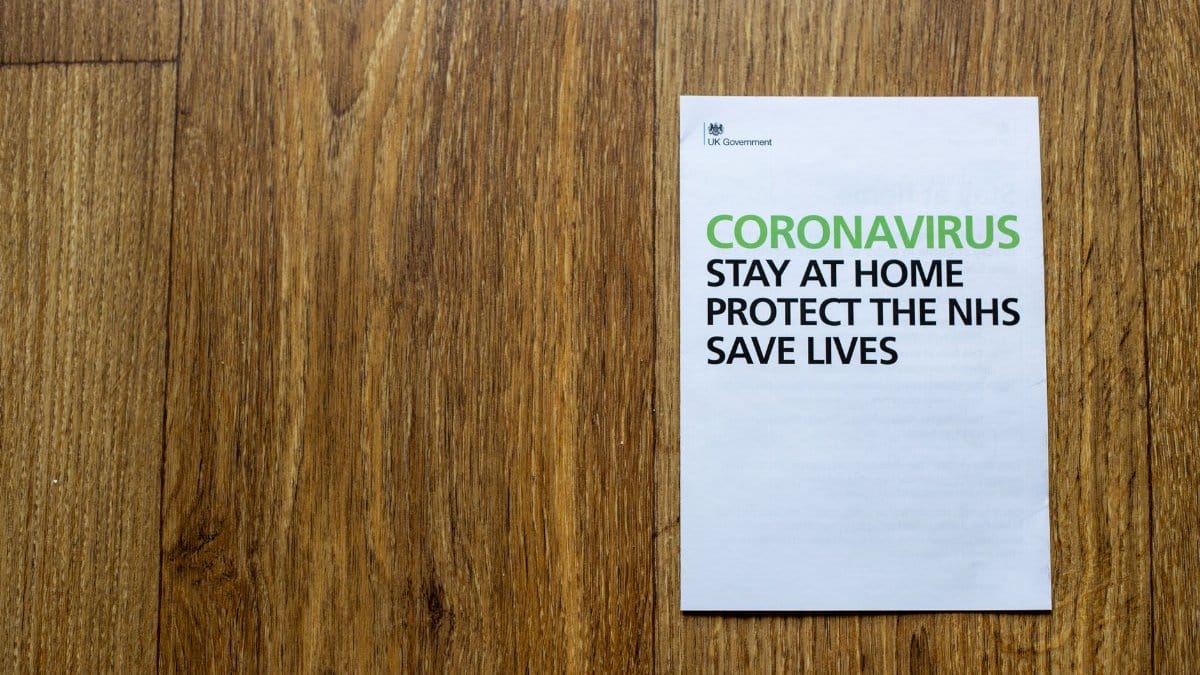 Top view wooden table with sheet of paper with advises regarding behavior during coronavirus pandemic