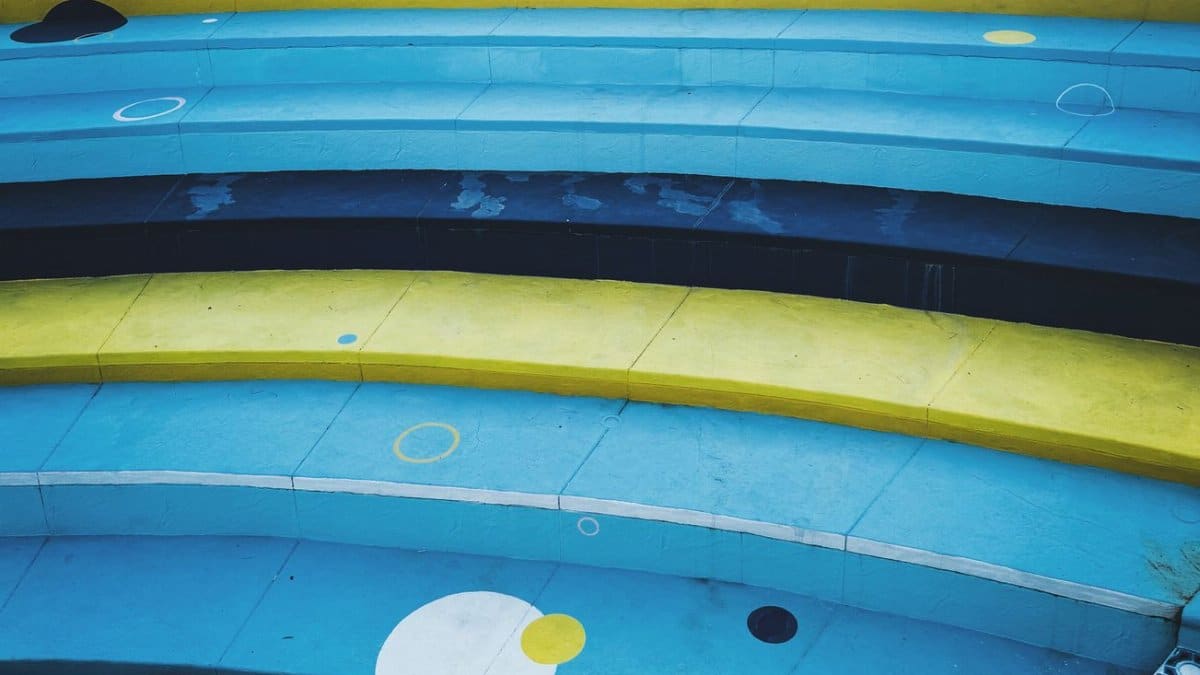 Vibrant blue and yellow painted steps create an abstract pattern in an outdoor public space.