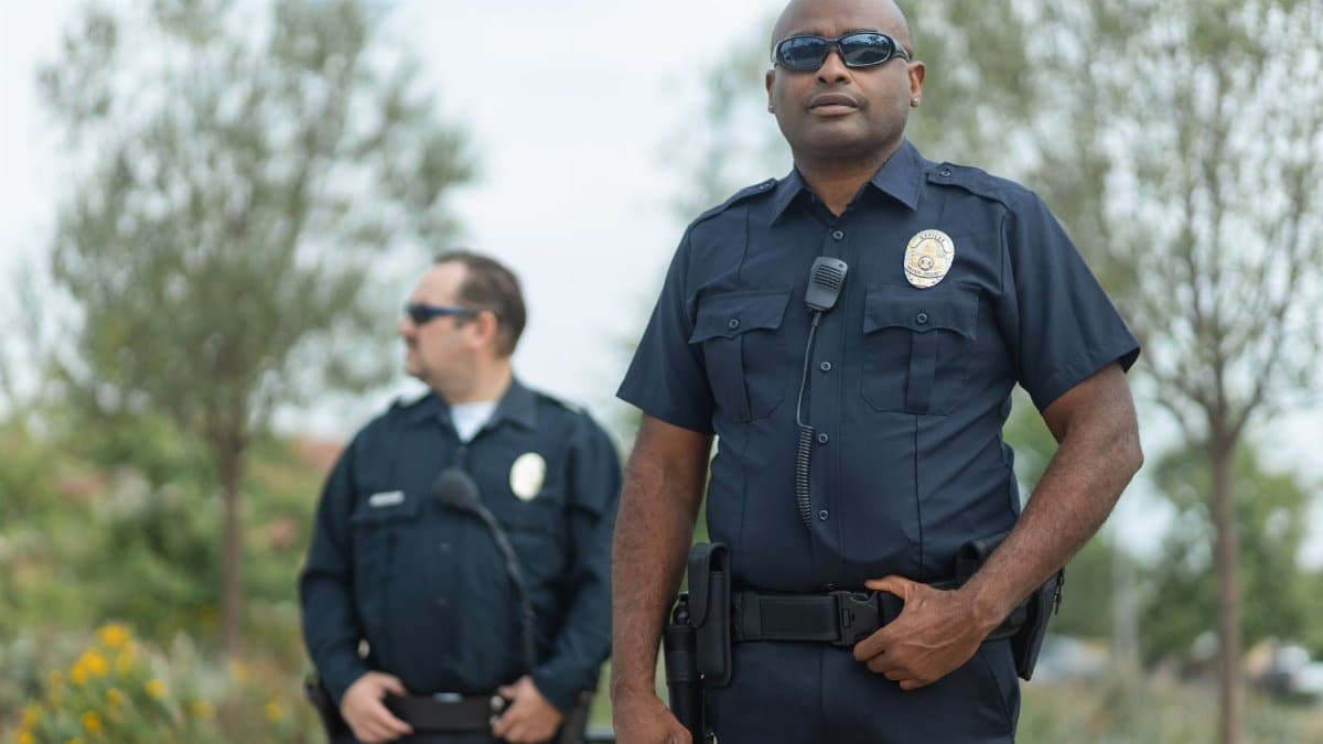 Two police officers in uniform ensure public safety, standing confidently outside.